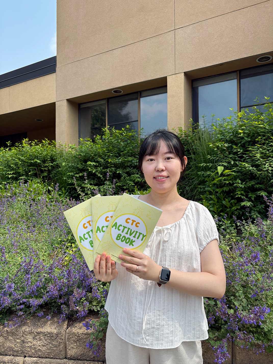 Creator and artist Jihye holding three books outside CTC